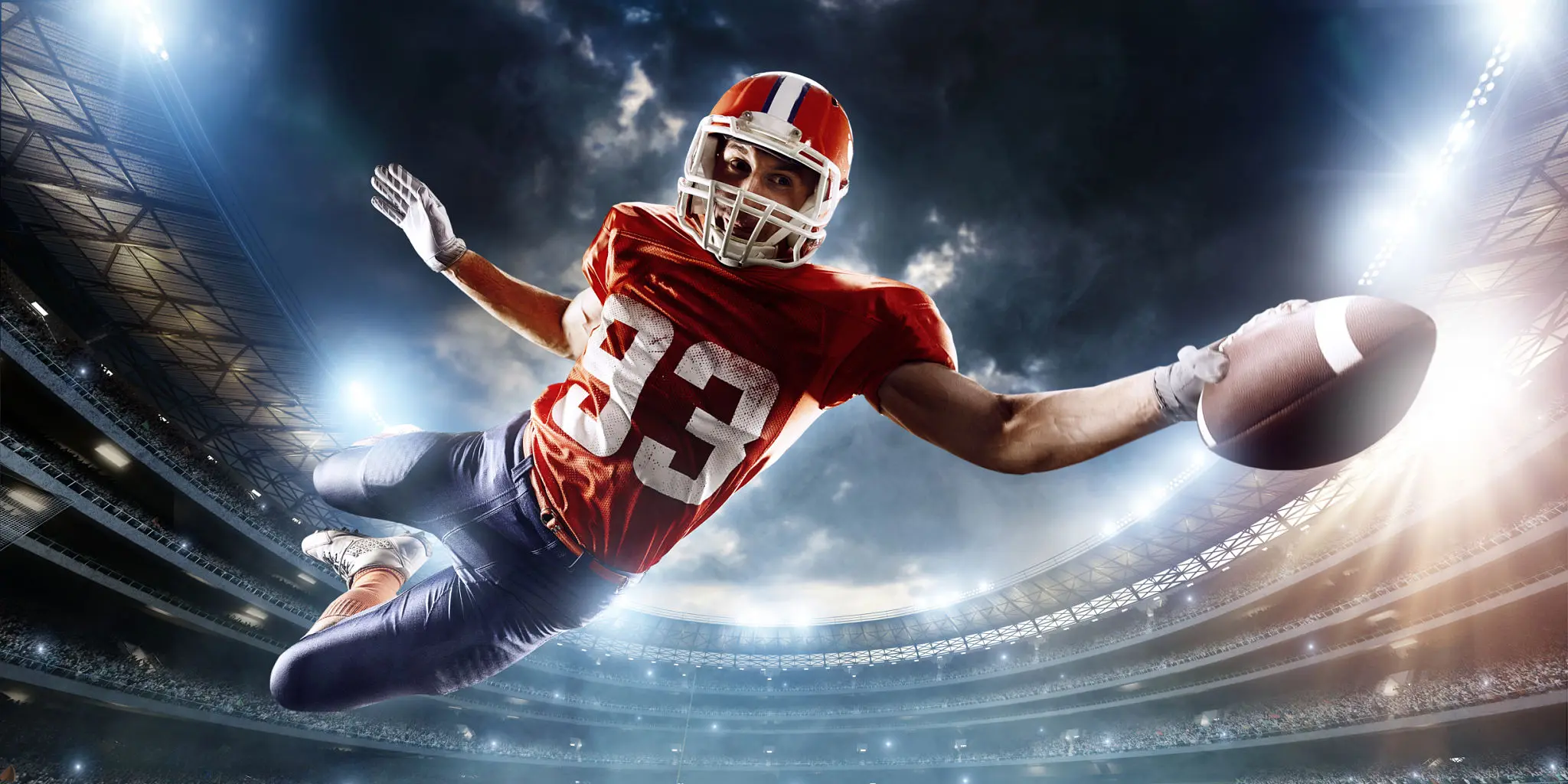 Football player leaping to catch ball.